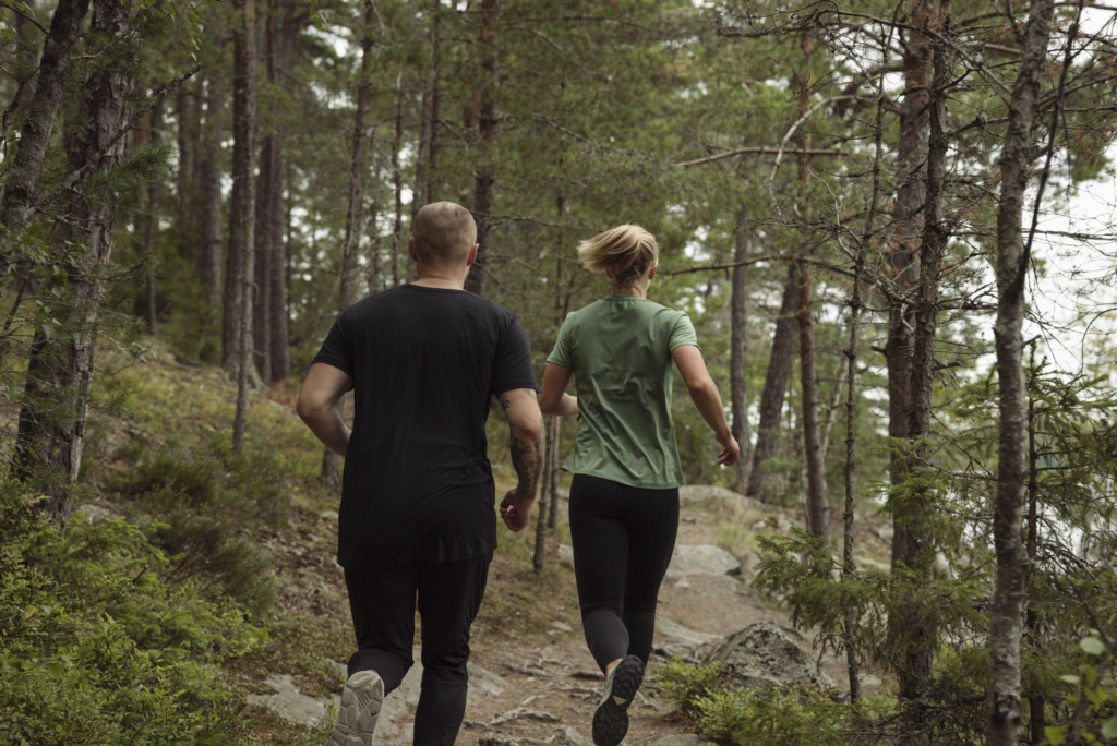 kvinna och man som springer i skogen