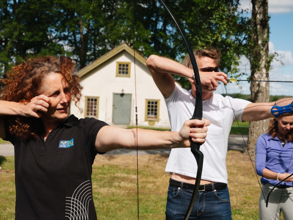 Instruktör visar hur man skjuter bågskytte