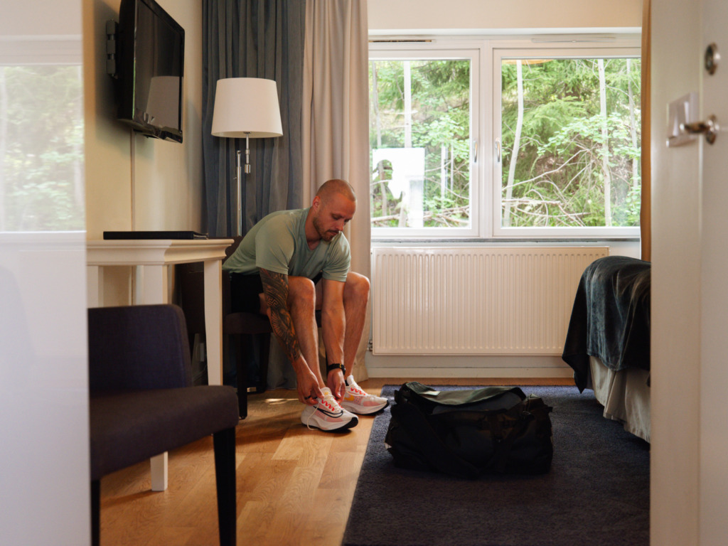 Gäst knyter skorna i hotellrum